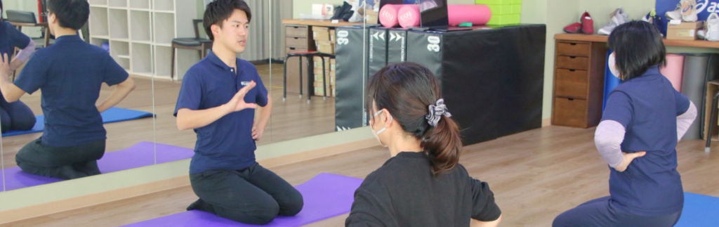 理学療法士がシニア向けピラティスグループレッスンで姿勢と体の使い方を指導している様子