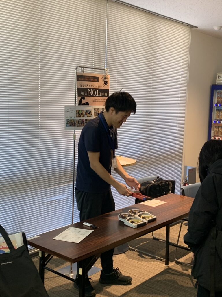 金沢区の市民講座で理学療法士が握力測定を行う様子 高齢者向け健康チェック